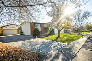 View of front of house featuring brick siding and an outbuilding