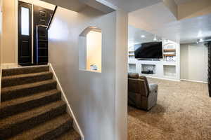 Staircase featuring built in features, a textured ceiling, and carpet