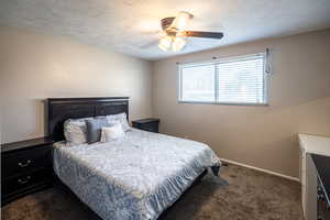 Carpeted bedroom with ceiling fan and a textured ceiling