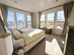Spacious primary bedroom with abundant natural light and amazing views of Oquirrh Lake