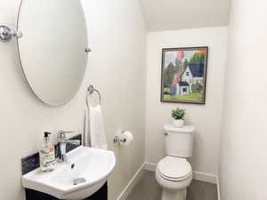 Crisp and clean half bathroom, equipped with dainty vanity and adjustable vanity mirror