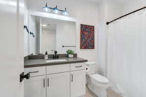 Spacious bathroom equipped with large vanity and crisp cabinetry with added modern contrasting hardware