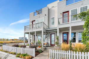 Stunning home front with welcoming front patio and upper balcony