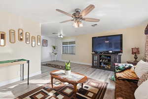 Living area with wood finished floors and a ceiling fan