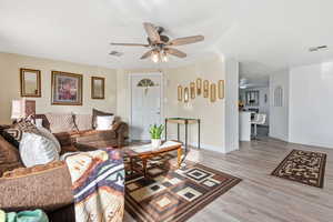 Living room with a ceiling fan and light wood finished floors