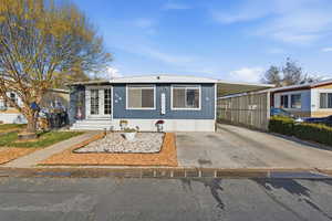 Manufactured / mobile home featuring concrete driveway and an attached carport