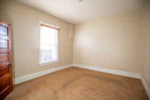 Spare room featuring baseboards and carpet flooring
