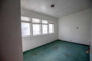 Carpeted empty room featuring baseboards