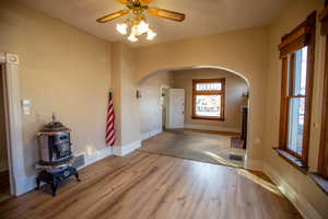 Foyer featuring arched walkways, wood finished floors, and ceiling fan