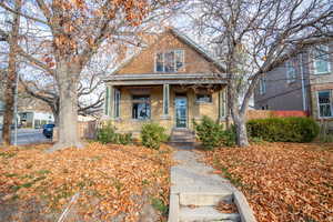 Bungalow-style home with covered porch and brick siding