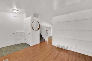 Entrance foyer with wood finished floors and stairway