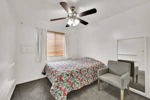 Carpeted bedroom featuring a ceiling fan