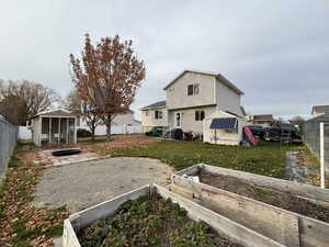 Back of house featuring a fenced backyard, a sunroom, and a garden