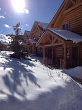 Snow covered property with log exterior