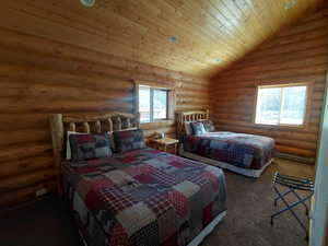 Carpeted bedroom with wood ceiling, log walls, lofted ceiling, and a baseboard heating unit