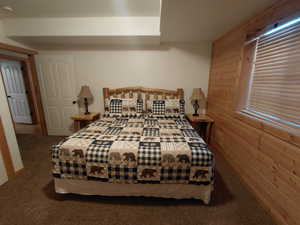 Bedroom with wooden walls and carpet
