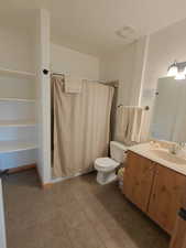 Full bathroom with a stall shower, vanity, and light tile patterned floors