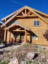 Log home with log siding and covered porch