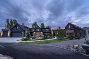 View of front of house featuring concrete driveway, an attached garage, and stone siding