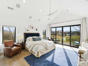 Bedroom with high vaulted ceiling, access to outside, multiple windows, a ceiling fan, and light wood-style floors