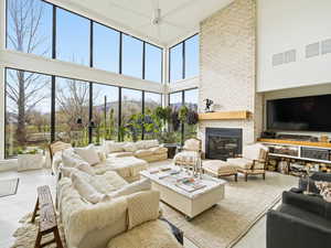 Living room featuring a towering ceiling and a brick fireplace