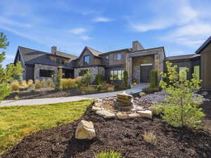 View of front of property featuring stone siding and a chimney