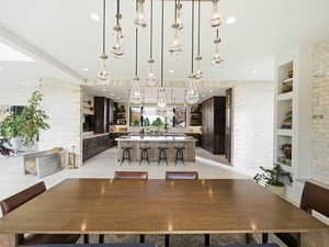 Dining area with built in features, brick wall, light tile patterned floors, and recessed lighting