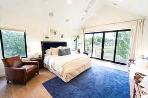 Bedroom featuring access to outside, high vaulted ceiling, wood-type flooring, multiple windows, and a ceiling fan