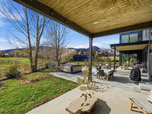 View of patio / terrace featuring a mountain view, a hot tub, and outdoor dining space