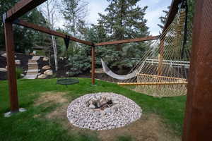 View of play area with a yard and a fire pit