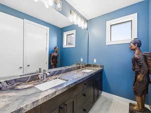 Bathroom featuring double vanity and baseboards
