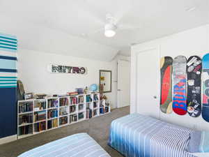 Bedroom with carpet floors and lofted ceiling
