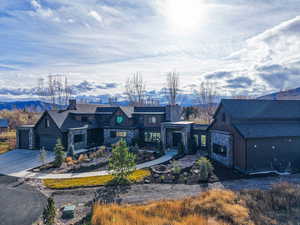 View of front of home with concrete driveway, stone siding, a mountain view, and an attached garage
