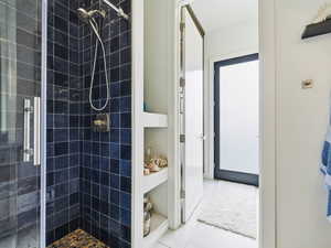 Bathroom featuring a shower stall and light tile patterned floors