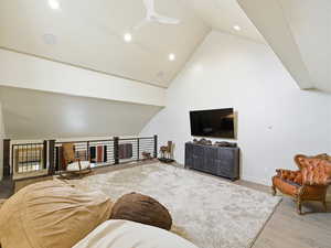 Living area with light wood finished floors, a ceiling fan, high vaulted ceiling, and recessed lighting