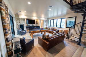 Living room with billiards, light wood finished floors, stairway, and recessed lighting