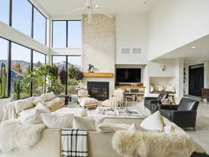Living area featuring a high ceiling, a brick fireplace, a mountain view, and ceiling fan