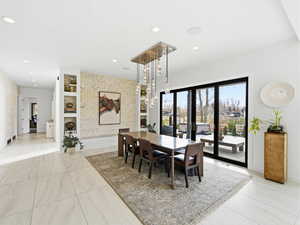 Dining space with a chandelier, recessed lighting, and brick wall