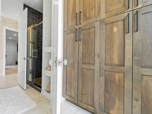 Full bathroom featuring a shower stall and light tile patterned floors