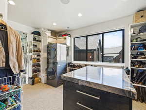 Spacious closet with stacked washer / drying machine and light carpet