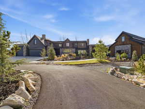 View of front facade with asphalt driveway and stone siding