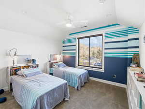 Bedroom featuring vaulted ceiling, ceiling fan, and dark colored carpet