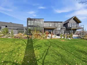 Back of house with a patio area and a lawn