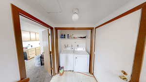 Washroom with washer and dryer, light floors, and light colored carpet