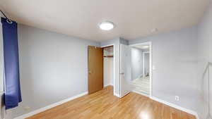 Unfurnished bedroom featuring light wood finished floors and a closet