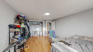 Bedroom with wood finished floors and a closet