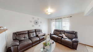 Living area with a textured ceiling and baseboards