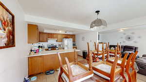 Dining room featuring light tile patterned floors and a tray ceiling
