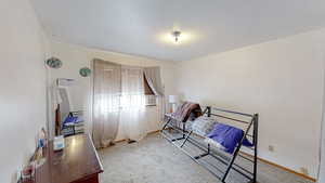 Bedroom with light colored carpet and a textured ceiling