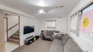 Living area featuring healthy amount of natural light, stairs, and carpet floors